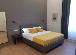 Camera moderna e accogliente con letto matrimoniale e dettagli gialli.