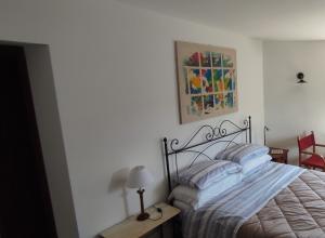 Camera accogliente con letto matrimoniale e arte colorata alle pareti.