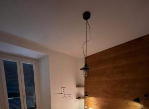 Camera accogliente con letto colorato, illuminazione calda e parete in legno.