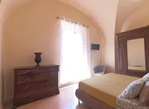 Camera accogliente con mobili antichi, luce soffusa, atmosfera serena.