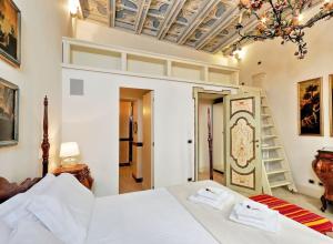 Camera elegante con soffitto decorato, lampadario floreale e arredi d'epoca.