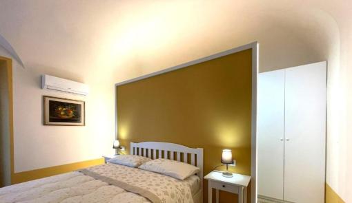 Camera accogliente, pareti gialle, letto comodo e atmosfera serena.